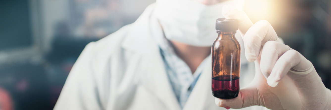 Lab worker holds a brown glass bottle