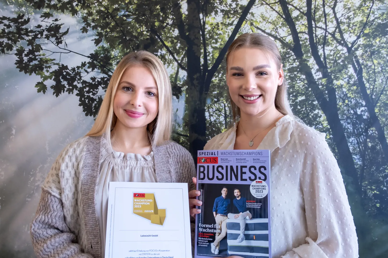 Madeline Holzwarth und Aileen Pikos zeigen den aktuellen Wachstumschampions-Zertifikat und die aktuellen Ausgabe von FOCUS Business