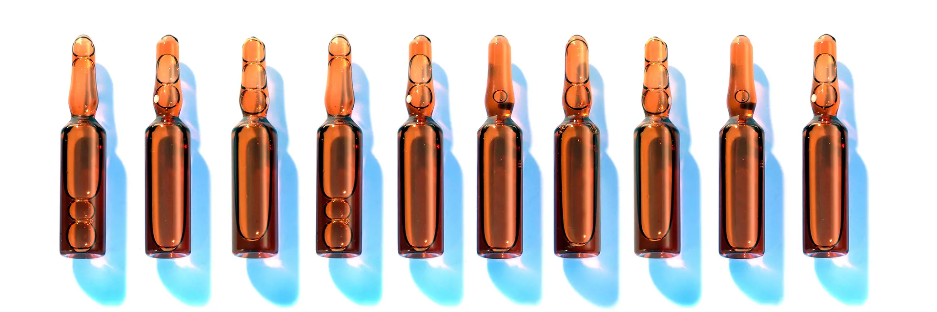 Brown ampoules with blue shadows on a white background